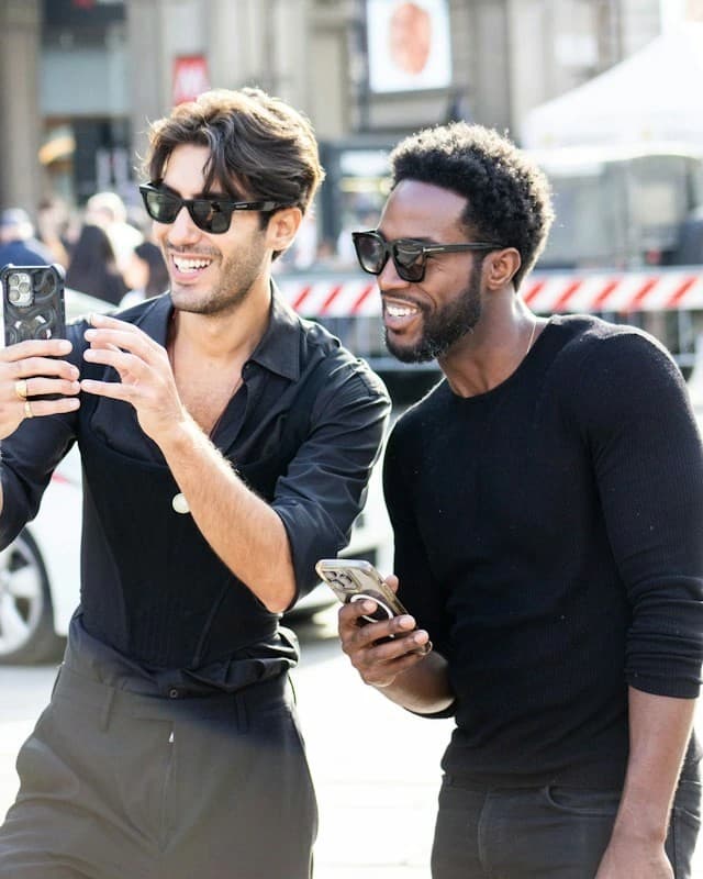 Two people smiling while looking at a phone